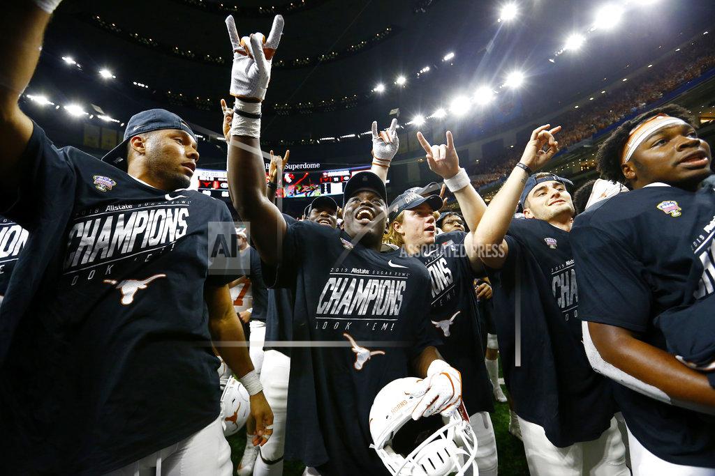 Butch Dill Texas players give the Hook 'em Horns sign after defeating Georgia 28-21 in the Sugar Bowl NCAA college football game in New Orleans, Tuesday, Jan. 1, 2019. (AP Photo/Butch Dill)