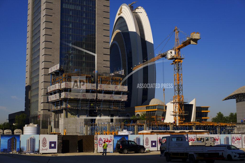 Pavel Golovkin A crane operates on a construction cite with the Crescent Tower Lusail in the background in Lusail downtown, Qatar, Thursday, Nov. 24, 2022. (AP Photo/Pavel Golovkin)