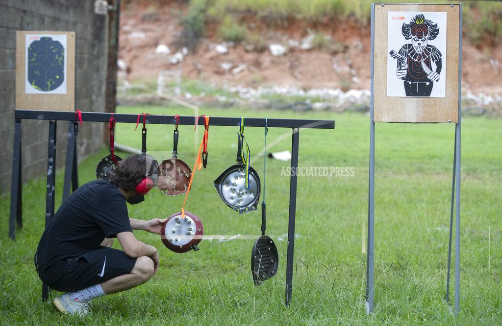 Andre Penner A man checks his aim on the makeshift targets frying pans at a shooting range in Americana, in the Sao Paulo state of Brazil, Saturday, March 6, 2021. Anti-gun activists, a former defense minister and high-ranked former policemen are appalled by the loosening of gun restrictions, saying allowing more weapons into Brazil will only invite more mayhem. (AP Photo/Andre Penner)