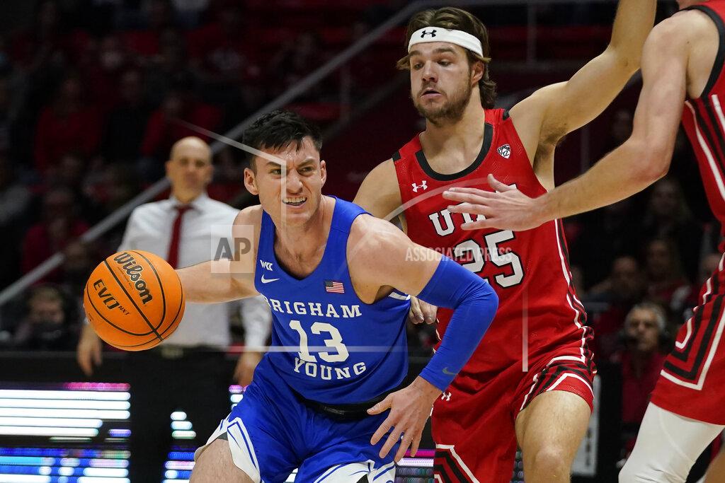 Rick Bowmer BYU guard Alex Barcello (13) drives around Utah guard Rollie Worster (25) during the first half of an NCAA college basketball game Saturday, Nov. 27, 2021, in Salt Lake City. (AP Photo/Rick Bowmer)