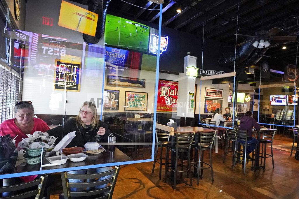 Cecelia Brockett, left, and Courtney Barefoot enjoy a lunch at the Winking Lizard Tavern, Monday, Nov. 16, 2020, in Beachwood, Ohio. Ohio Governor Mike DeWine issued a new health warning Sunday to limit mass gatherings. (AP Photo/Tony Dejak)