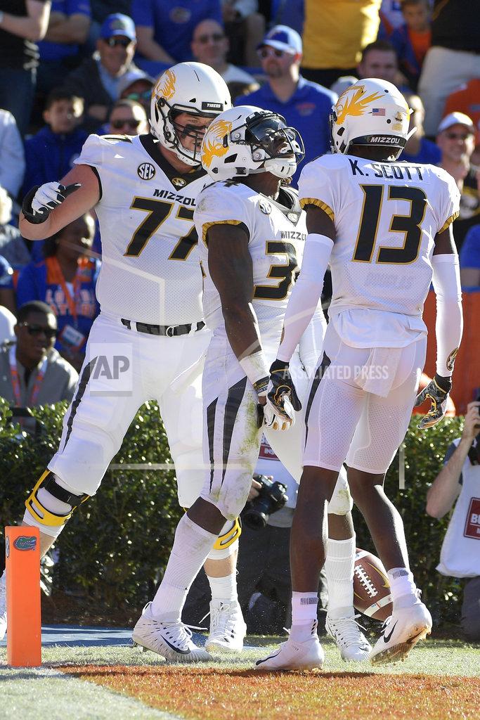 Phelan M. Ebenhack Missouri running back Larry Rountree III, center, celebrates with offensive lineman Paul Adams (77) and wide receiver Kam Scott (13) after rushing for a 27-yard touchdown during the first half of an NCAA college football game against Florida Saturday, Nov. 3, 2018, in Gainesville, Fla. (AP Photo/Phelan M. Ebenhack)