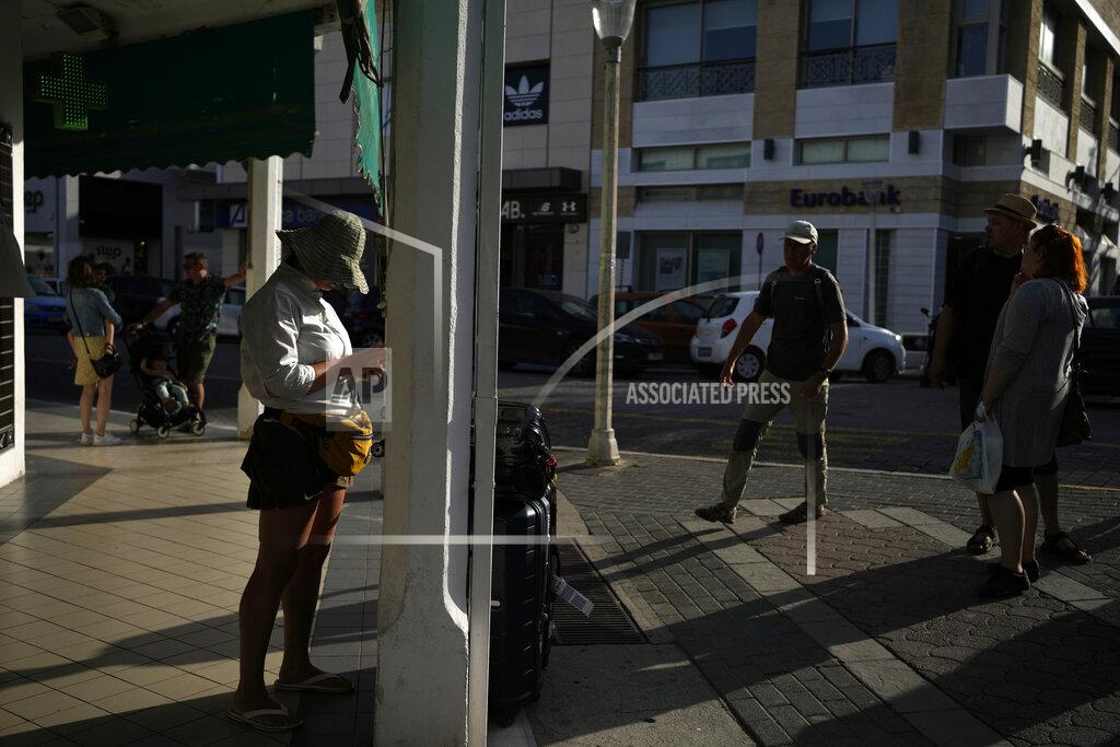 Thanassis Stavrakis Tourists wait near a bus stop in the main town of the Aegean Sea island of Rhodes, southeastern Greece, Tuesday, May 10, 2022. Russia's war in Ukraine has accelerated inflation across Europe, with prices for energy, materials and food surging at rates not seen for decades. Inflation is expected to hit nearly 7% this year in the 27-nation EU and is contributing to slowing growth forecasts. (AP Photo/Thanassis Stavrakis)