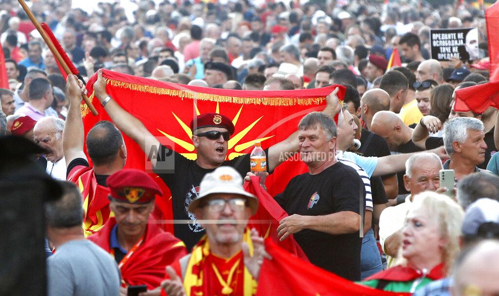 Boris Grdanoski A protester holds the old national flag during a protest in front of the government building in Skopje, North Macedonia, on Saturday, July 2, 2022. Tens of thousands of people have gathered late on Saturday in North Macedonia's capital Skopje to protest the latest French presidency proposal on solving bilateral disputes with Bulgaria that gave directions for small Balkan country to open membership talks with the European Union. (AP Photo/Boris Grdanoski)