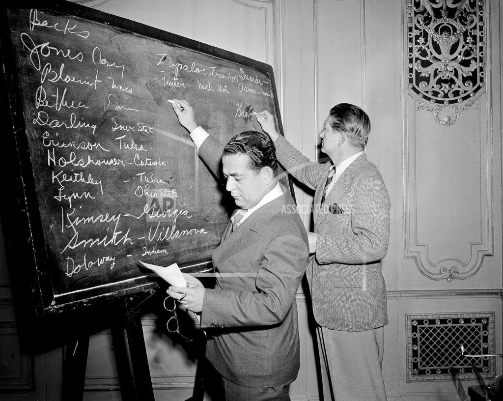 Harry L. Hall FILE - In this April 18, 1943, file photo, Fred Mandel, foreground, president of the Detroit Lions, and Charles "Chile" Walsh, assistant coach of the Cleveland Rams, look over prospects at the player draft of the NFL in Chicago. The number of rounds fluctuated through the years, in part because of competition from the All-America Football Conference in the 1940s, but also because college football grew and more players were available. (AP Photo/Harry L. Hall, File)