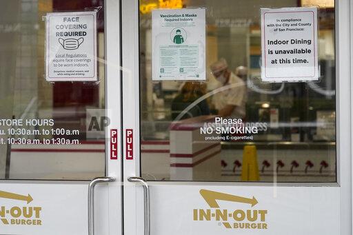 FILE - In this Oct. 20, 2021, file photo, signs advising vaccination and face mask requirements and no indoor dining are displayed on the door of an In-N-Out restaurant in San Francisco's Fisherman's Wharf. The restaurant's indoor dining was shut down this month by health authorities for not demanding proof of vaccination. (AP Photo/Jeff Chiu, File)
