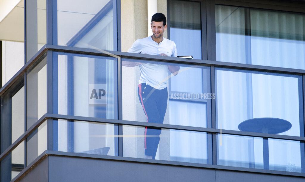 Morgan Sette Serbia's Novak Djokovic stands on the balcony at his accommodation in Adelaide, Australia, Tuesday, Jan. 19, 2021. Australian Open tournament director Craig Tiley defended Djokovic for appealing to Australian Open organizers to ease restrictions so players could move to private residences with tennis courts. (Morgan Sette/AAP Image via AP)