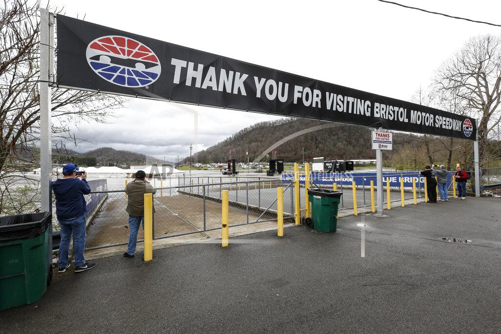 Wade Payne John Cody, left, and Bob Sampson from Cedarville, Ohio, left, take a photo of water flooding the vendor area is seen as races for both the Truck Series and NASCAR Cup Series auto race was postponed due to inclement weather at Bristol Motor Speedway, Sunday, March 28, 2021, in Bristol, Tenn. (AP Photo/Wade Payne)