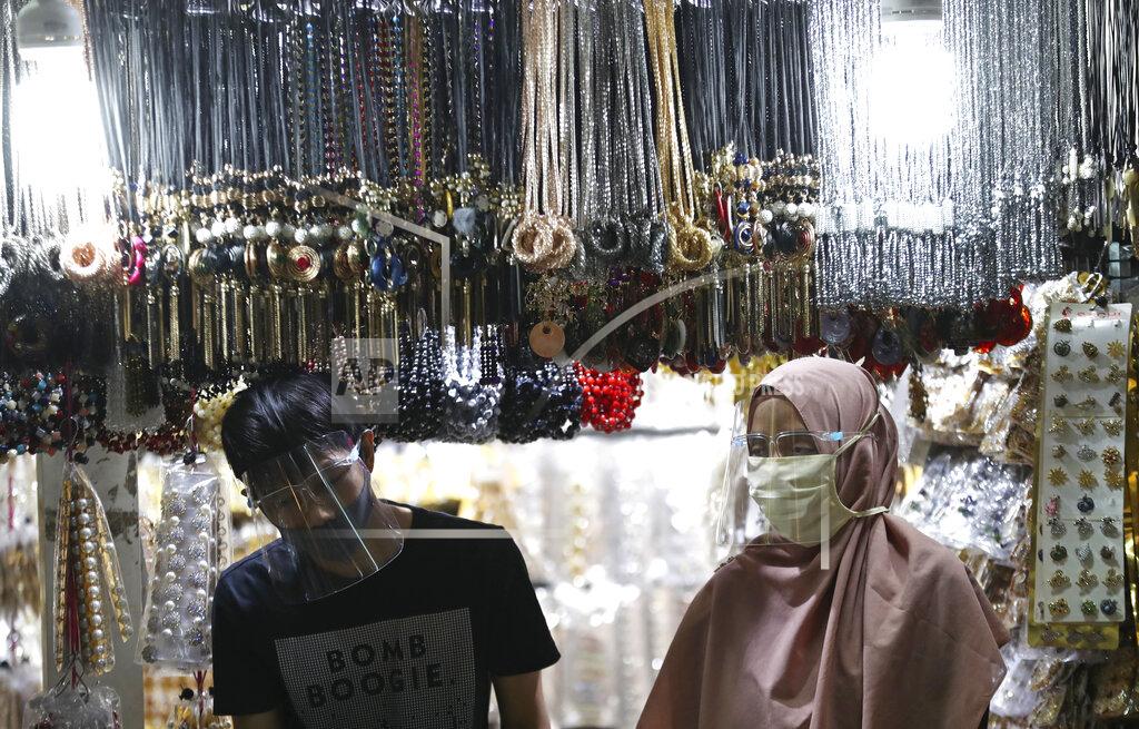 Achmad Ibrahim Accessories venders wearing face mask wait customers amid fears of the new coronavirus outbreak at a market in Jakarta, Indonesia Tuesday, June 30, 2020.(AP Photo/Achmad Ibrahim)
