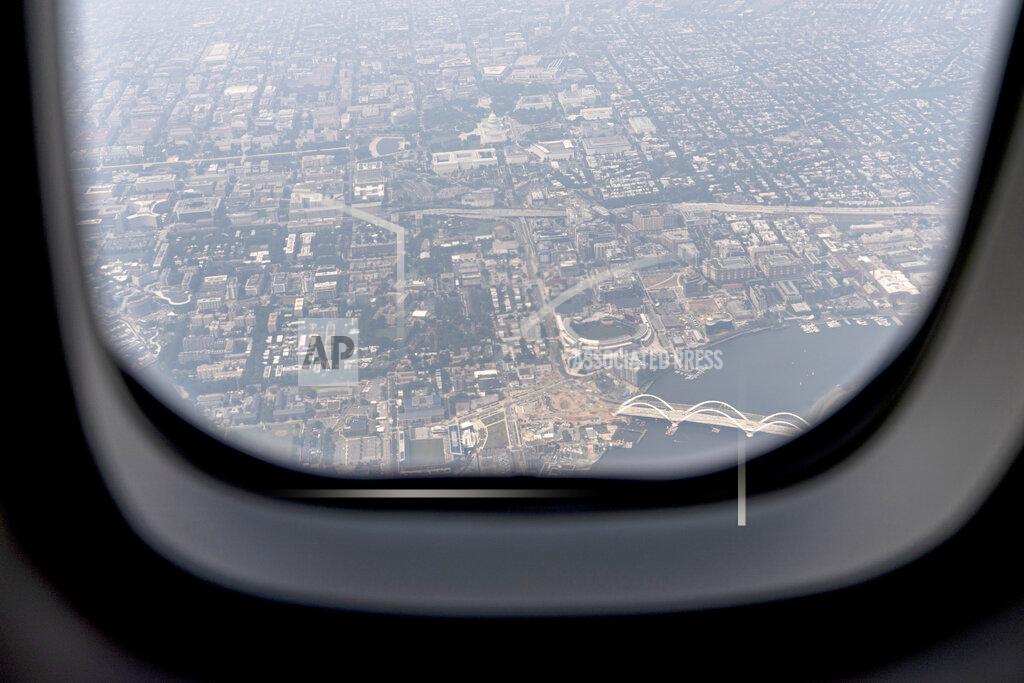Andrew Harnik The U.S. Capitol is visible through a hazy sky from smoke from a window on Air Force One as it flies over downtown Washington, Wednesday, July 21, 2021. President Joe Biden is traveling to Cincinnati for a CNN town hall. (AP Photo/Andrew Harnik)