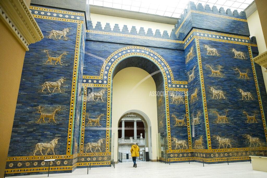 Markus Schreiber Metal restoration specialist Gert Jendritzki walks through the Babylon's Ishtar Gate as he leaves the Museum of the Ancient East in Berlin, Germany, Monday, March 15, 2021. Museums throughout Germany closed at the beginning of November as coronavirus cases increased. Under new regulations, some of the collections on Berlin's Museum Island, one of the city's cultural highlights and a UNESCO World Heritage site, are now allowed to re-open to visitors. (AP Photo/Markus Schreiber)