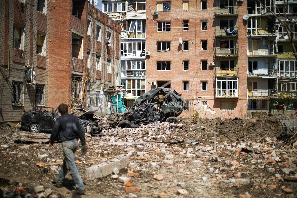 Francisco Seco A man walks next to heavily damaged residential buildings and destroyed cars after Russian bombing in Bakhmut, eastern Ukraine, Tuesday, May 24, 2022. The town of Bakhmut has been coming under increasing artillery strikes, particularly over the last week, as Russian forces try to press forward to encircle the city of Sieverodonetsk to the northeast. (AP Photo/Francisco Seco)