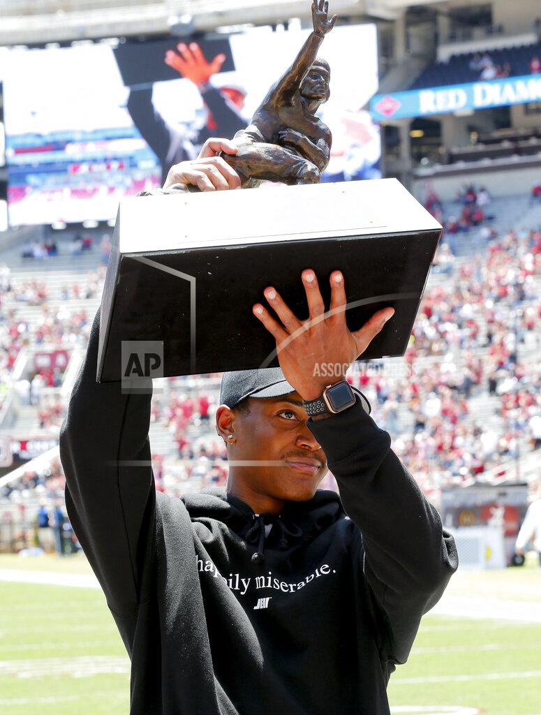 Gary Cosby Heisman Trophy winner Devonta Smith lifts the trophy for fans to see after a special presentation during Alabama's spring NCAA college football game at Bryant-Denny Stadium, Saturday, April 17, 2021, in Tuscaloosa, Ala. (Gary Cosby/The Tuscaloosa News via AP)