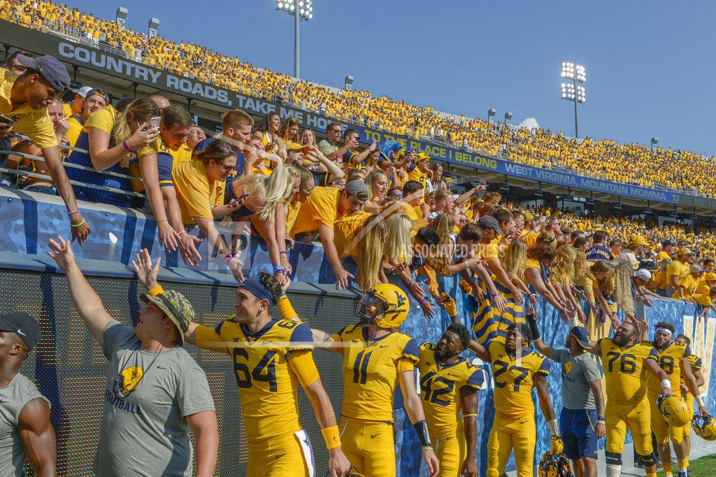 Craig Hudson West Virginia lineplayers high-five fans after defeating Kansas 38-22 in an NCAA college football game against Kansas in Morgantown, W. Va., Saturday Oct. 6, 2018. (Craig Hudson/Charleston Gazette-Mail via AP)
