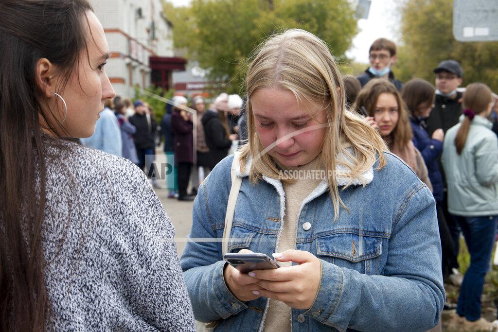 Anastasia Yakovleva Students stand near the Perm State University in Perm, about 1,100 kilometers (700 miles) east of Moscow, Russia, Monday, Sept. 20, 2021. A gunman opened fire in a university in the Russian city of Perm on Monday morning, leaving at least eight people dead and others wounded, according to Russia's Investigative Committee. (AP Photo/Anastasia Yakovleva)