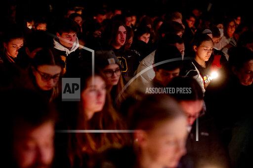 Oxford High School sophomore Allison Hepp, 15, holds a candle as she bows her head in prayer during a vigil after the Oxford High School school shootings, Tuesday, Nov. 30, 2021, at LakePoint Community Church in Oxford, Mich. (Jake May/The Flint Journal via AP)