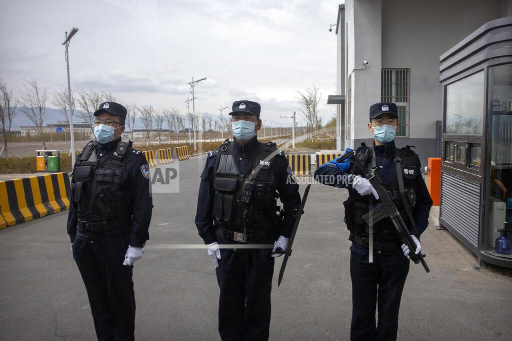 Mark Schiefelbein FILE - Police officers stand at the outer entrance of the Urumqi No. 3 Detention Center in Dabancheng in western China's Xinjiang Uyghur Autonomous Region on April 23, 2021. State officials took AP journalists on a tour of a "training center" turned detention site in Dabancheng sprawling over 220 acres and estimated to hold at least 10,000 prisoners - making it by far the largest detention center in China and among the largest on the planet. (AP Photo/Mark Schiefelbein, File)