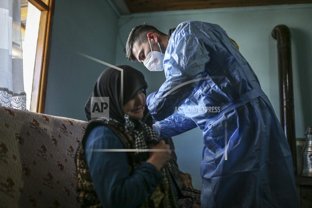 Emrah Gurel Zeynep Yigit, 70, left, is administered a dose of the CoronaVac vaccine made by China's Sinovac Biotech Ltd., by health worker Yusuf Duran at her house in the isolated village of Gumuslu in the district of Sivas, central Turkey, Friday, Feb. 26, 2021. Health care workers, older people and people with serious medical conditions were among the first to receive the jab. (AP Photo/Emrah Gurel)