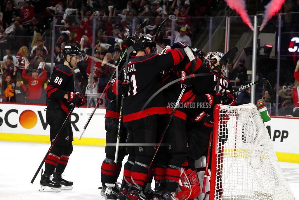 Karl B Deblaker Carolina Hurricanes players celebrate around goaltender Antti Raanta following their win over the Boston Bruins in Game 7 of an NHL hockey Stanley Cup first-round playoff series in Raleigh, N.C., Saturday, May 14, 2022. (AP Photo/Karl B DeBlaker)