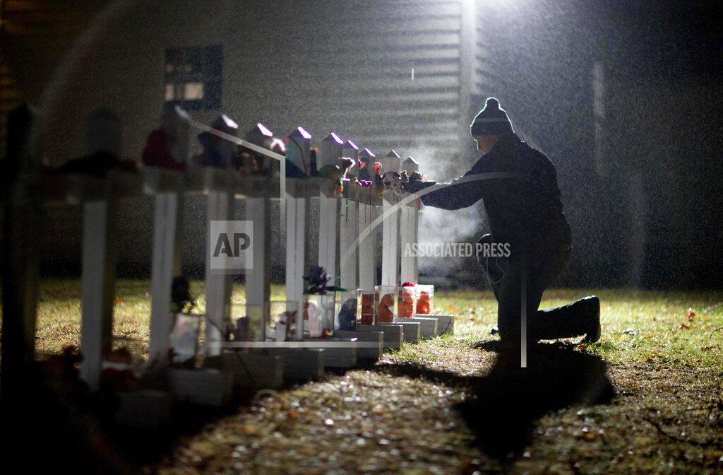 David Goldman FILE - Frank Kulick, adjusts a display of wooden crosses, and a Jewish Star of David, representing the victims of the Sandy Hook Elementary School shooting, on his front lawn, Monday, Dec. 17, 2012, in Newtown, Conn. After a weekend of gun violence in America, Saturday, May 14, 2022, when shootings killed and wounded people grocery shopping, going to church and simply living their lives, the nation marked a milestone of 1 million deaths from COVID-19. The number, once unthinkable, is now a pedestrian reality in the United States, just as is the reality of the continuing epidemic of gun violence that kills tens of thousands of people a year. (AP Photo/David Goldman, File)