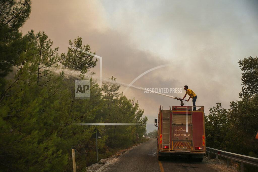 Emre Tazegul Firefighters work in the smoke-engulfed Mazi area as wildfires rolled down the hill toward the seashore, forcing people to be evacuated, in Bodrum, Mugla, Turkey, Sunday, Aug. 1, 2021. More than 100 wildfires have been brought under control in Turkey, according to officials. The forestry minister tweeted that five fires are continuing in the tourist destinations of Antalya and Mugla.(AP Photo/Emre Tazegul)