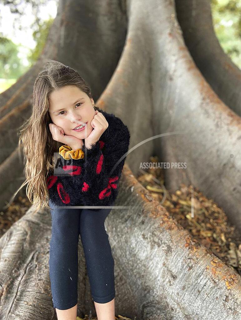 Anna Berghamre In this photo provided by her family, Niki Jolene Berghamre-Davis, 11, sits on the roots of a gum tree in Port Melbourne, Australia, on April 30, 2020. While sad about all the people lost to the virus pandemic, Niki is hopeful that the shutdowns are teaching the world how to live in ways that will help the environment. (Anna Berghamre via AP)