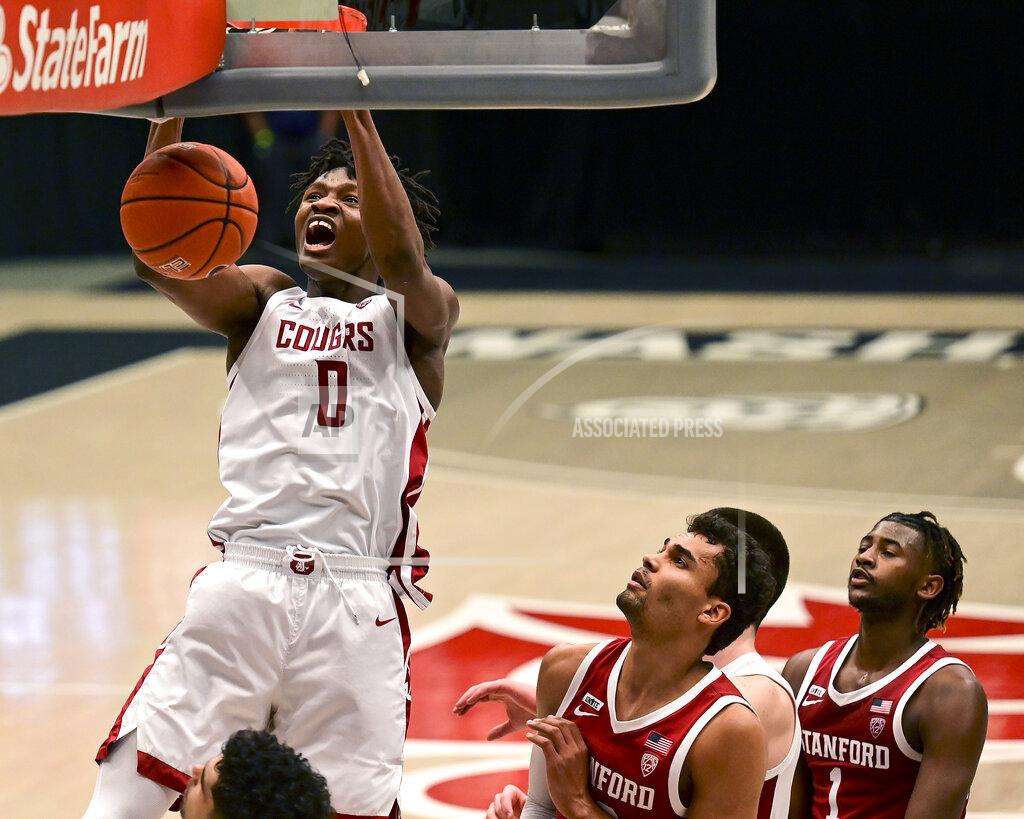 FILE - In this Saturday, Feb. 20, 2021 file photo, Washington State center Efe Abogidi, left, dunks the ball next to Stanford forward Oscar da Silva (13) during the first overtime of an NCAA college basketball game, in Pullman, Wash. A serious knee injury nearly ended Efe Abogidi's basketball career but he's now back on the NBA draft radar. The 19-year-old Nigerian is known for his high-flying dunks and plays for Washington State in the Pac-12. But his journey from West Africa to the West Coast was atypical with stops in Senegal and Australia. (AP Photo/Pete Caster, File)