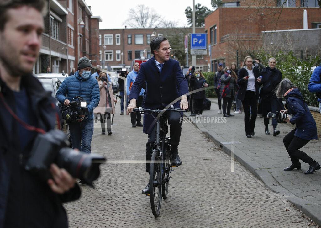 Peter Dejong Dutch caretaker Prime Minster Mark Rutte leaves on his bicycle after casting his vote in a general election in The Hague, Wednesday, March 17, 2021. Polling stations have opened opened across the Netherlands from Monday in a general election that has been spread over three days to allow people to vote safely during the coronavirus pandemic. (AP Photo/Peter Dejong)