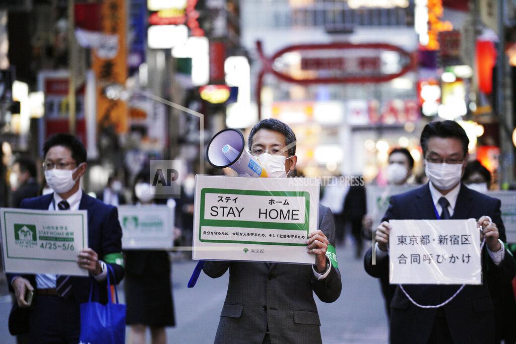 Eugene Hoshiko FILE - In this April 24, 2020, file photo, staff of the Tokyo Metropolitan Government urge people to go home from the Kabukicho entertainment district in the Shinjuku Ward in Tokyo. Under Japan's coronavirus state of emergency, people have been asked to stay home. Many are not. Some still have to commute to their jobs despite risks of infection, while others are dining out, picnicking in parks and crowding into grocery stores with scant regard for social distancing. (AP Photo/Eugene Hoshiko, File)