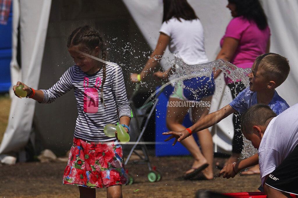 Marco Ugarte A child tosses a balloon during a water balloon fight at a camp in the Iztapalapa borough of Mexico City, Tuesday, May 24, 2022. Mexico City will close the camp that has hosted hundreds of Ukrainian refugees for the past month. Now that a U.S. program vetting refugees and then allowing them to fly to the U.S. is operational, authorities say the camp is no longer needed. (AP Photo/Marco Ugarte)