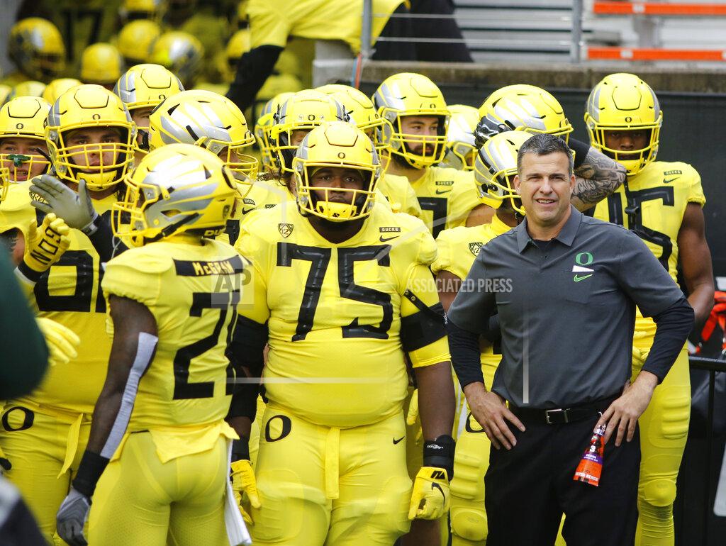 Timothy J. Gonzalez FILE - In this Nov. 23, 2018, file photo, Oregon coach Mario Cristobal stands with players before the team's NCAA college football game against Oregon State in Corvallis, Ore. The Ducks are the highest-ranked Pac-12 team and the North Division favorite. They go into Saturday night’s game against Auburn, the opener of Cristobal’s second season, with a three-game winning streak after a 9-4 season. (AP Photo/Timothy J. Gonzalez, File)