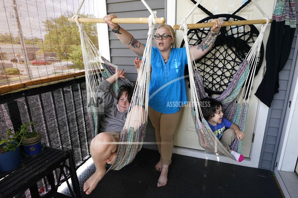 Elise Amendola In this July 28, 2021 photo, Christina Darling plays with her sons Kayden, 10, left, and Brennan, 4, at home in Nashua, N.H. Darling and her family have qualified for the expanded child tax credit, part of President Joe Biden's $1.9 trillion coronavirus relief package. "Every step closer we get to a livable wage is beneficial. That is money that gets turned around and spent on the betterment of my kids and myself," said Darling, a housing resource coordinator who had been supplementing her $35,000-a-year salary with monthly visits to the Nashua Soup Kitchen and Shelter's food pantry. (AP Photo/Elise Amendola)