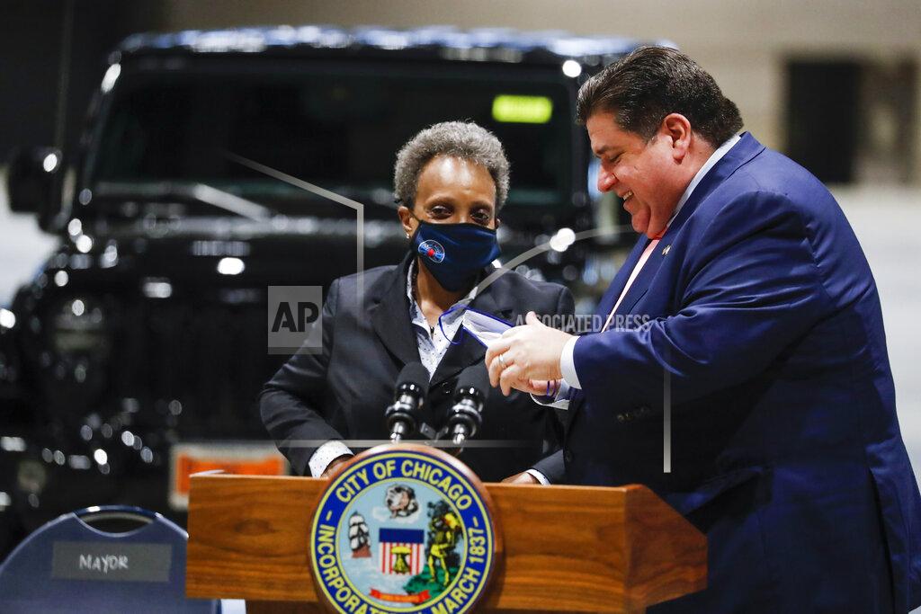 Jose M. Osorio Governor J.B. Pritzker and Mayor Lori Lightfoot talk following a news conference regarding updates on Chicago's reopening efforts at McCormick Place in Chicago on Tuesday, May 4, 2021. (Jose M. Osorio /Chicago Tribune via AP)
