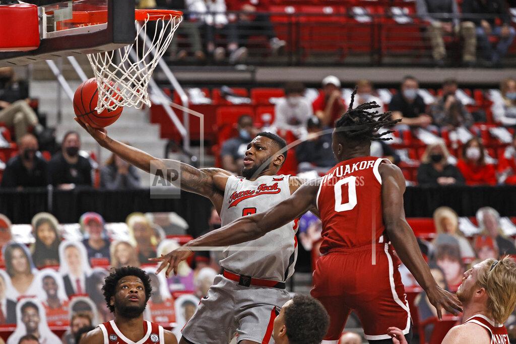 Brad Tollefson Texas Tech's Jamarius Burton (2) lays up the ball around Oklahoma's Victor Iwuakor (0) during the second half of an NCAA college basketball game Monday, Feb. 1, 2021, in Lubbock, Texas. (AP Photo/Brad Tollefson)