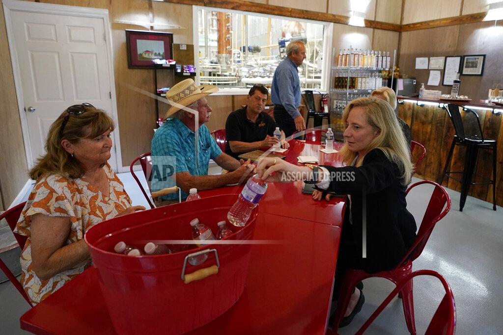 Steve Helber In this Monday, June 7, 2021, photo Rep Abigail Spanberger, D-Va., right, reaches for a bottle of water as she starts a roundtable discussion st the Hilltop distillery in Maidens, Va. Spanberger held a roundtable discussion with distillers to discuss COVID-19 reopening challenges experienced by small businesses & regulatory issues facing central Virginia distilleries. (AP Photo/Steve Helber)