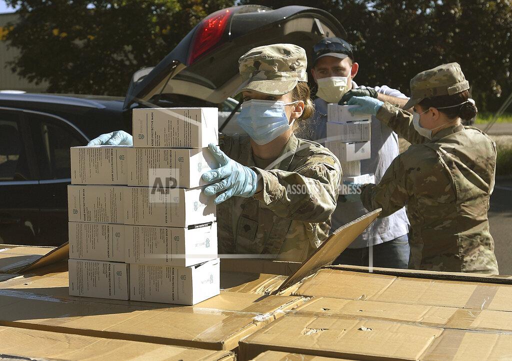 Mark Ylen FILE - In this Wednesday, May 27, 2020, file photo, Oregon National Guard's Ashley Smallwood, of Springfield, Ore., counts out boxes of face masks to be given to Willamette Valley farmers while participating in a distribution event at the Oregon State University Extension Service-Linn County office in Tangent, Ore. Oregon adopted a controversial rule on Tuesday, May 4, 2021 that indefinitely extends coronavirus mask and social distancing requirements in all businesses in the state. State officials say the rule, which garnered thousands of public comments, will be in place until it is “no longer necessary to address the effects of the pandemic in the workplace.” (Mark Ylen/Albany Democrat-Herald via AP, file)