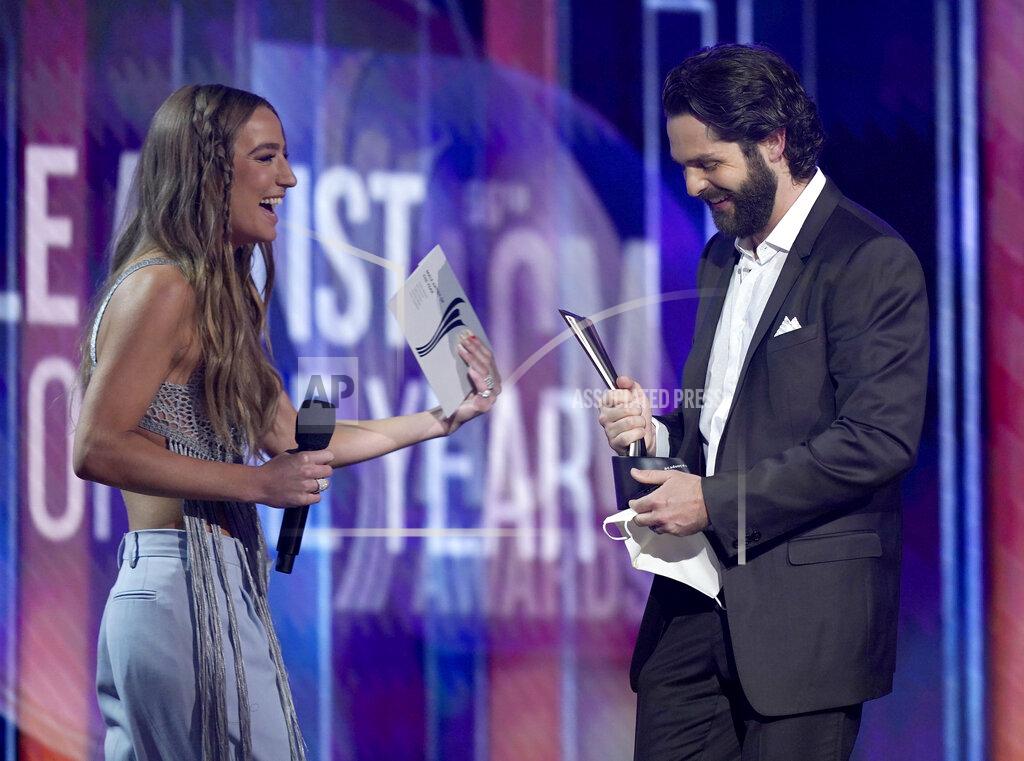 Mark Humphrey Ingrid Andress, left, presents the award for male artist of the year to Thomas Rhett at the 56th annual Academy of Country Music Awards on Sunday, April 18, 2021, at the Grand Ole Opry in Nashville, Te nn. (AP Photo/Mark Humphrey)