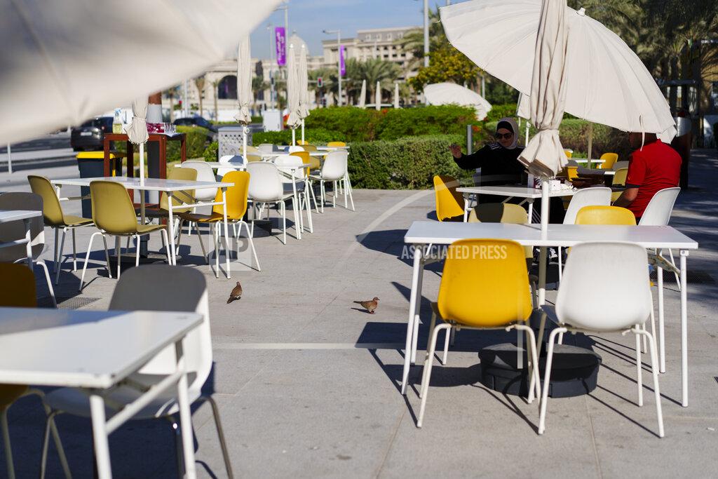Pavel Golovkin A woman feeds birds in a street cafe at Lusail Marina Corniche in Lusail downtown, Qatar, Thursday, Nov. 24, 2022. (AP Photo/Pavel Golovkin)