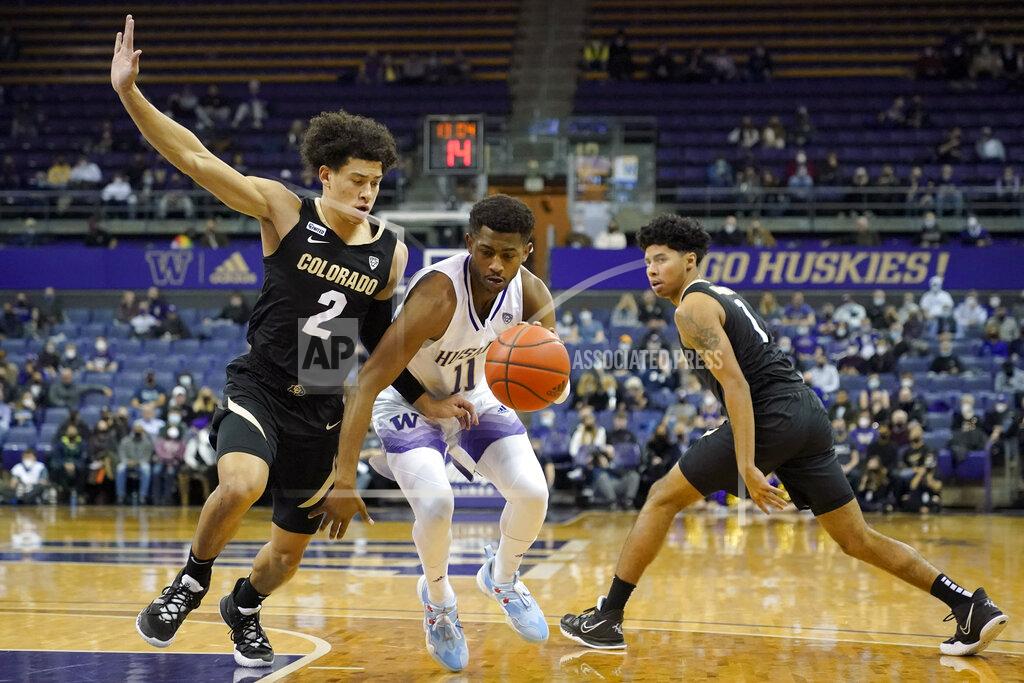 Ted S. Warren Washington guard Daejon Davis (11) drives around guard KJ Simpson (2) as Colorado guard Julian Hammond III, right, looks on during the first half of an NCAA college basketball game, Thursday, Jan. 27, 2022, in Seattle. (AP Photo/Ted S. Warren)