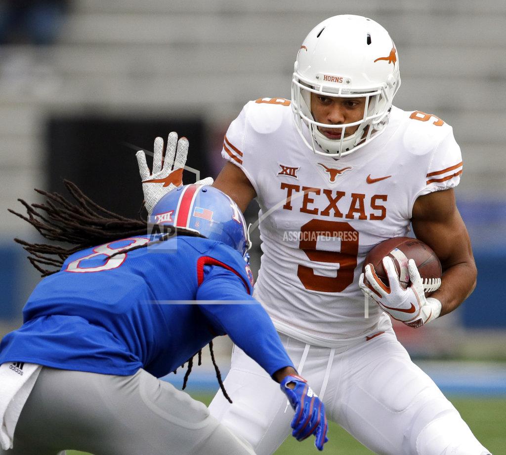Orlin Wagner Texas wide receiver Collin Johnson (9) tries to stop a tackle by Kansas cornerback Shakial Taylor (8) during the first half of an NCAA college football game in Lawrence, Kan., Friday, Nov. 23, 2018. (AP Photo/Orlin Wagner)