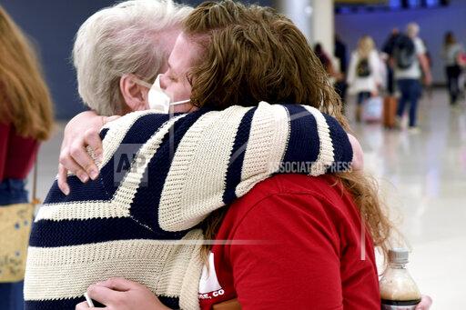 Jocelyn Ragusin hugs her mother, who arrived at Denver International Airport from Rapid City, South Dakota, on Tuesday, Nov. 23, 2021. Ragusin said about seven or eight family members would be gathering for the holiday and that the group had not discussed each other's vaccination status beforehand. Ragusin's husband contracted COVID-19 and spent four days in the intensive care unit in October 2020, but the family is willing to accept a certain level of risk to have a sense of community back. (AP Photo/Thomas Peipert)