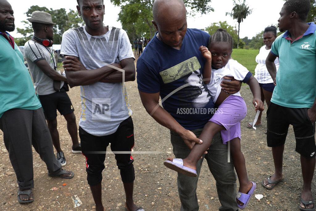 Arnulfo Franco Haitian migrant Jean Bernadeau show insects bites on a girl's legs, at a migrant camp amid the new coronavirus pandemic in Lajas Blancas, Darien province, Panama, Saturday, Aug. 29, 2020. "We know there is a strong illness out there. We can't stay here forever." Said Bernadeau, a who arrived from Chile after living there for five years and saving $4,000 to continue his journey, "Here we live like prisoners in a jail." He said. (AP Photo/Arnulfo Franco)