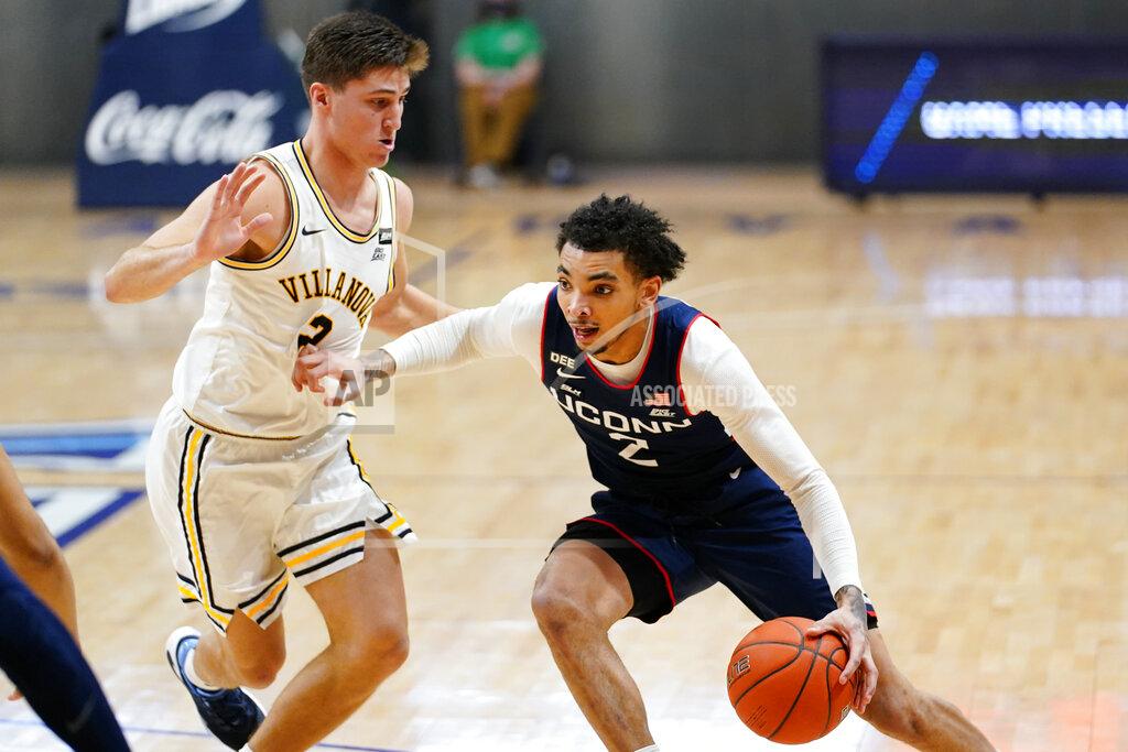 Matt Slocum Connecticut's James Bouknight, right, dribbles past Villanova's Collin Gillespie during the second half of an NCAA college basketball game, Saturday, Feb. 20, 2021, in Villanova, Pa. (AP Photo/Matt Slocum)