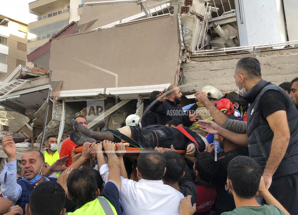 Ismail Gokmen Rescue workers and local people carry a wounded person found in the debris of a collapsed building, in Izmir, Turkey, Friday, Oct. 30, 2020, after a strong earthquake in the Aegean Sea has shaken Turkey and Greece. Turkey's Disaster and Emergency Management Presidency said Friday's earthquake was centered in the Aegean at a depth of 16,5 kilometers (10.3 miles) and registered at a 6.6 magnitude. (AP Photo/Ismail Gokmen)