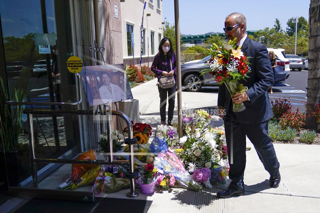 Ashley Landis A man places flowers at a memorial honoring Dr. John Cheng sits outside his office building on Tuesday, May 17, 2022, in Aliso Viejo, Calif. Cheng, 52, was killed in Sunday's shooting at Geneva Presbyterian Church. (AP Photo/Ashley Landis)
