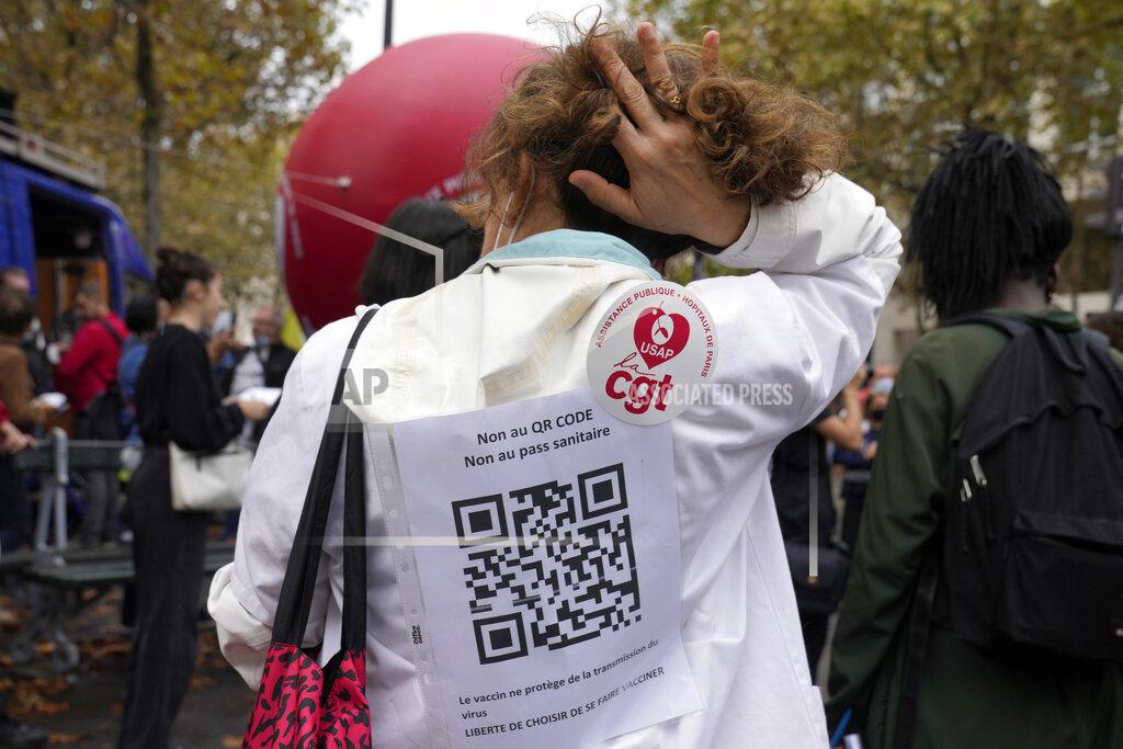 Francois Mori A medical worker wearing a paper reading "No to QR code, No to Health Pass , the vaccin does not prevent for the virus transmission, Freedom to choose to be vaccinated" during a protest gathering outside the Health Ministry in Paris, Tuesday, Sept. 14, 2021 against a law requiring them to get vaccinated by Wednesday or risk suspension from their jobs. The law is aimed at protecting patients from new surges of COVID-19. Most of the French population is vaccinated but a vocal minority are against the vaccine mandate. (AP Photo/Francois Mori)