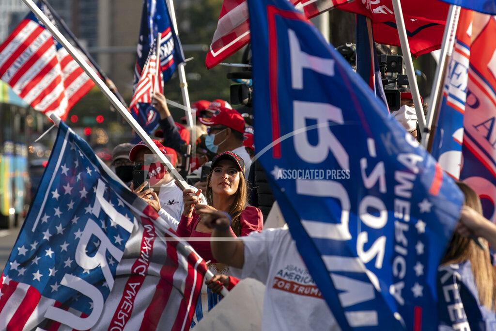 President Donald Trump supporters cheer outside of Walter Reed National Military Medical Center in Bethesda, Md., before Trump lifted off on Marine One Monday, Oct. 5, 2020. Stepping gingerly, Trump walked out the military hospital Monday night where he has been receiving an unprecedented level of care for COVID-19, immediately igniting a new controversy by declaring that despite his illness the nation should fear the virus that has killed more than 210,000 Americans. (AP Photo/Jose Luis Magana)