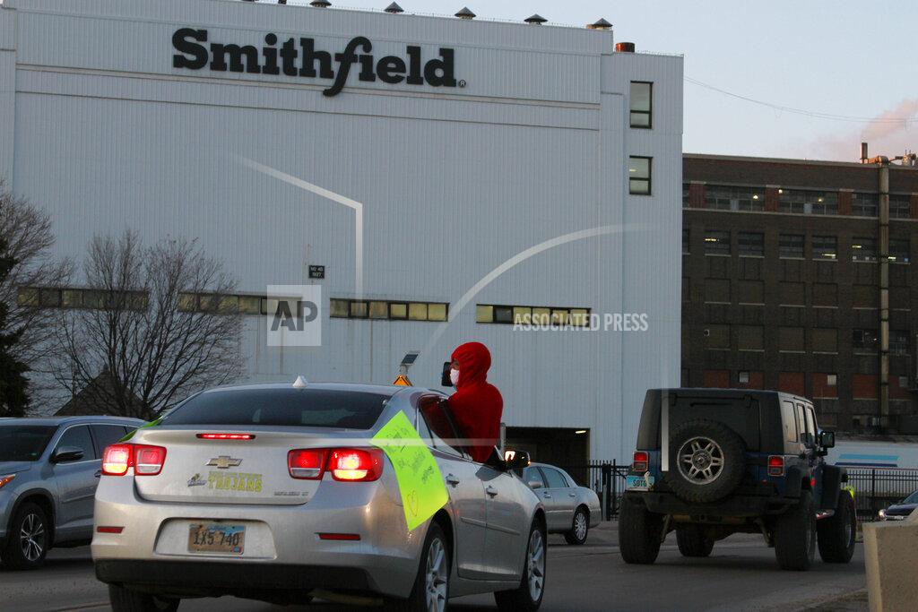 Stephen Groves FILE - In this April 9, 2020 file photo employees and family members protest outside a Smithfield Foods processing plant in Sioux Falls, S.D. At least 59,000 meatpacking workers became ill with COVID-19 and 269 workers died when the virus tore through the industry last year, which is significantly more than previously thought, according to a new U.S. House report released Wednesday, Oct. 27, 2021. (AP Photo/Stephen Groves File)
