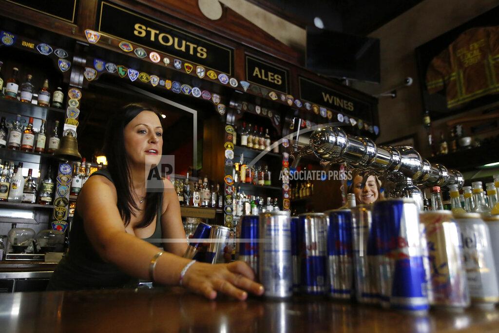 Rich Pedroncelli FILE — In this March 17, 2020 file photo bartender Courtney Schrag places beverage cans on the bar as she other employees prepare to close de Vere's Irish Pub in Sacramento, Calif. On Friday April 17, 2020, the California Employment Development Department announced the state's unemployment rate jumped to 5.3% in March, up from 3.9% the previous month. Job losses in the leisure and hospitality industry led the decline. The pub closed due to Gov. Gavin Newsom' s guidelines restricting bars and restaurants caused the coronavirus outbreak, and will reopen when the restrictions are lifted. (AP Photo/Rich Pedroncelli, File)