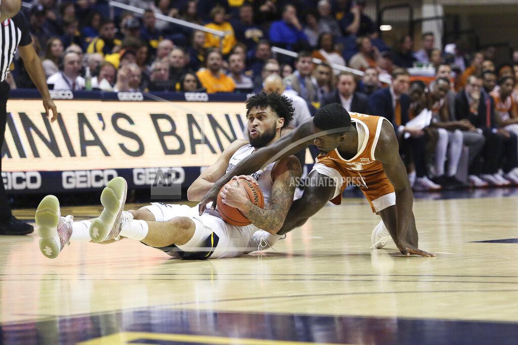 Kathleen Batten West Virginia guard Jermaine Haley (10) and Texas guard Courtney Ramey (3) scramble for a loose ball during the first half of an NCAA college basketball game Monday, Jan. 20, 2020, in Morgantown, W.Va. (AP Photo/Kathleen Batten)